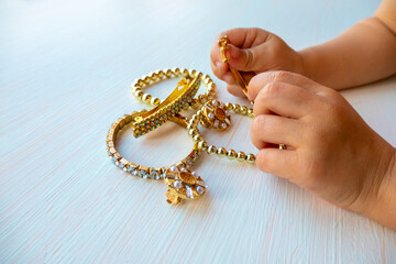  childrens hands play with gold jewelry and bijouterie, on white background. concept of womens...