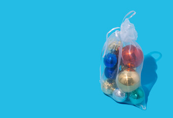 Christmas baubles in eco bag on a blue background, the concept of the new year minimalism