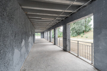 Empty unfinished interior of a modern concrete concrete room with a colonnade.