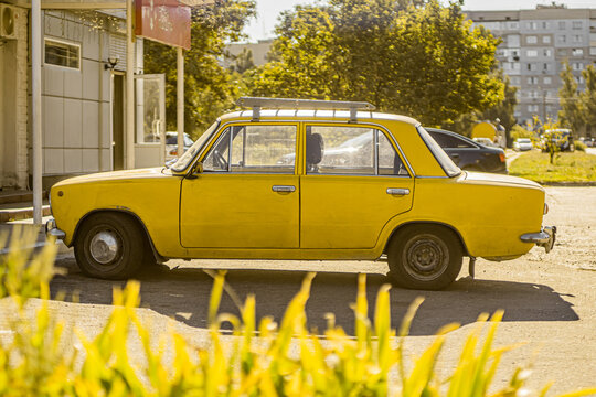 Yellow Zhiguli car on the street on a sunny day. Old vintage soviet car. Kaniv, Cherkasy Oblast, Ukraine - September 2021.