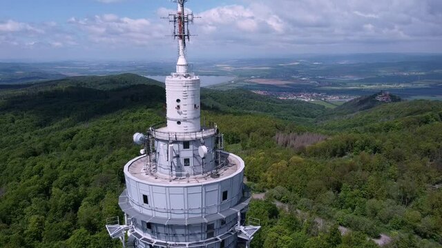 Nahaufnahme aus der Luft von Antennen und Sendetechnik f&uuml;r Mobilfunk und Telekommunikation in waldiger Berglandschaft