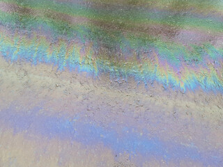 The Gasoline slick on the asphalt. Oil slick close-up.