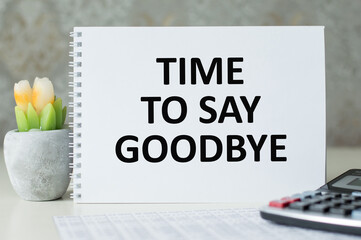 TIME TO SAY GOODBYE is written on a notepad on an office desk with office accessories.