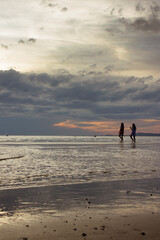 Fototapeta na wymiar Silueta de mujeres caminando por la playa
