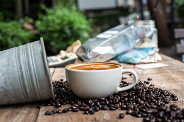 Hot latte art coffee with coffee bean on wooden table