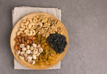 plate with nuts and raisins on a light background