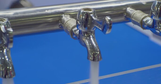 modern technologies. testing and demonstration of the work of modern equipment for water treatment. jets of clean water are poured from several metal mixer taps.Close-up.