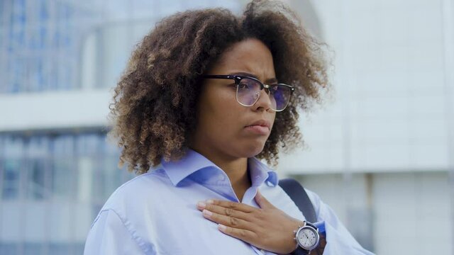 Black curly-haired woman coughing, chocked on food, feeling discomfort in chest