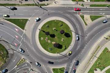Top down aerial view of a busy street traffic circle roundabout on a main road in an urban area