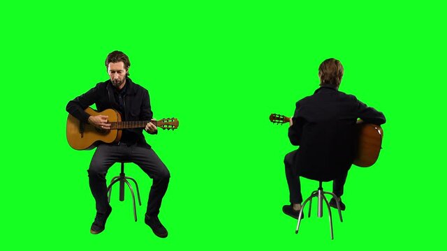 Playing Acoustic Guitar On Green Screen, Man Sitting Front And Back. Man playing acoustic guitar on a green screen background for replacement. Front and back of man