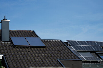 Solarthermie-  und Photovoltaik Panele auf zwei Hausdächern..Ein Sinnbild für Solarenergie und...