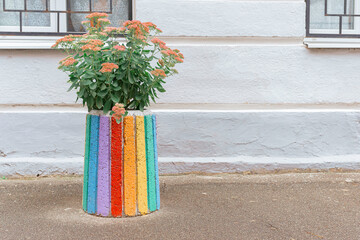 Bright street flowerpot near the building on the sidewalk