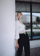 a beautiful girl in a white shirt walks around the city, a model girl in the city