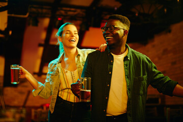 Young happy couple dancing and having fun in a bar at night.