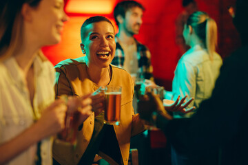 Cheerful African American woman having fun with her friends during the night out in a bar.