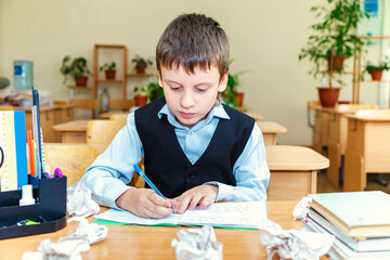 Serious schoolboy in the classroom.