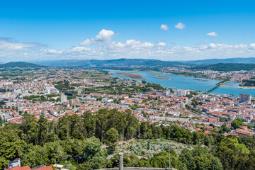 Fototapeta na wymiar Trees and construction of the city of Viana do Castelo with two bridges over the river Lima and mountains in the background, PORTUGAL