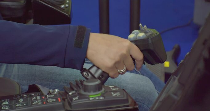 Close-up, the driver controls the car with the joystick.The worker presses the joystick buttons while driving the machine.