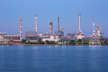 Twilight scene of oil refinery plant of Petrochemistry  front water reflection.