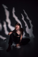 beautiful girl in a black bodice in the studio, chiaroscuro on her face