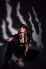 beautiful girl in a black bodice in the studio, chiaroscuro on her face