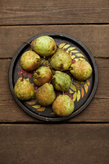 harvest pears on a round tray, wooden background