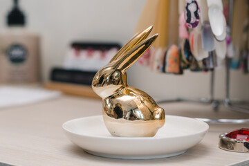 Golden decorative toy in the shape of a rabbit in a nail salon
