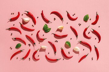 Raw red hot chili peppers, few garlic cloves and fresh green basil leaves, black pepper grains cast...