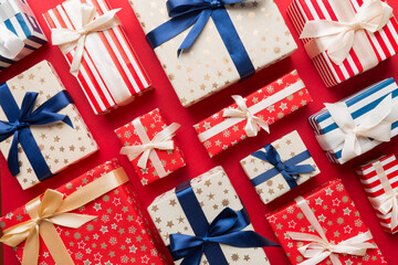 Fototapeta premium A lot of Christmas gift boxes in colored paper decorated on table, Top view close up. Many present New Year gift