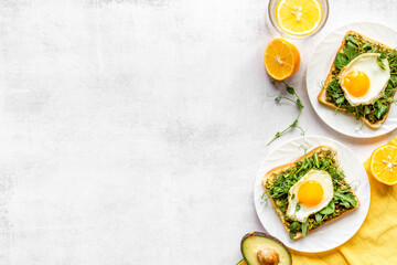 Open sandwich with eggs and avocado on plate. Overhead view