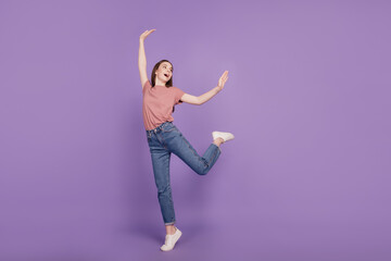 Cheerful young woman girl posing dancing look empty space isolated on violet background