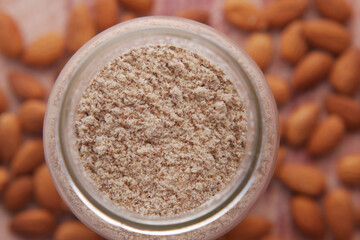 almond powder in a jar and almond on table 
