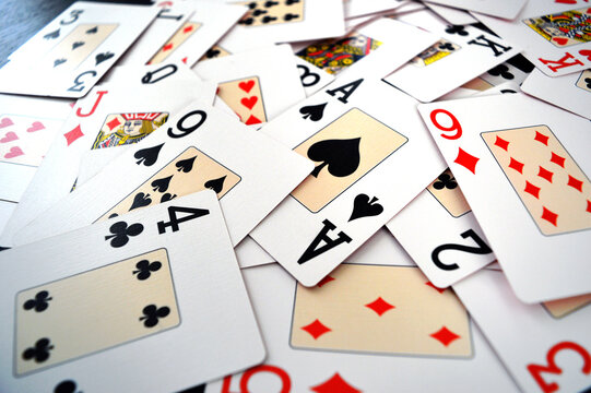 Poker Game Cards - Photo of cards mixed on a table showing all suits - Hearts, Spades, Diamonds and Clubs