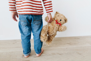 little boy holding his best friend teddy bear indoor