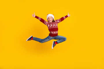 Fototapeta na wymiar Full body photo of positive cheerful small girl jump up make thumbs up promoter isolated on yellow color background