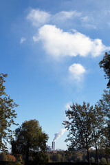city park trees and distant fuming factory chimneys, Lappeenranta Finland