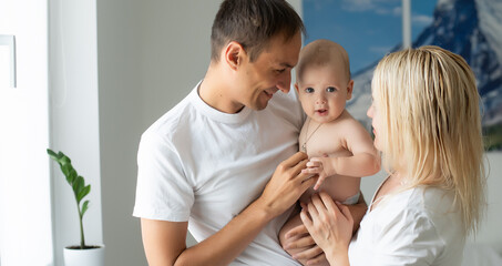 Portrait of happy young parents with baby at home