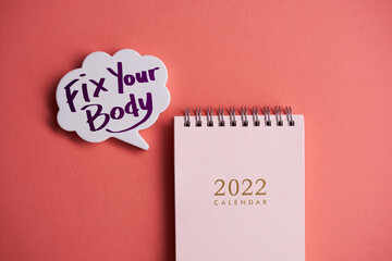  calendar 2022 with speech bubble written fix your body on orange background