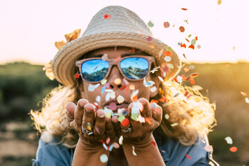 beautiful defocused woman blow confetti from hands. celebration and event concept. happiness and...