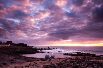 Sunset landscape at the beach with sea ocean and waves in background - dramatic sky with sun and clouds - dusk light and horizon