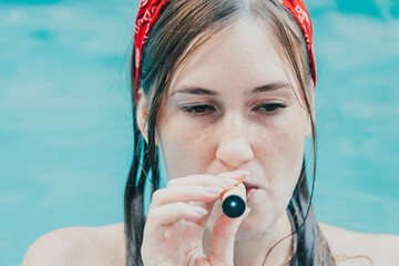 Woman smoking with electronic cigarette. Young woman smoking electronic cigarette in outdoors pool