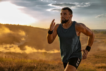 Runner concept. Athletic man running trail on sunset wearing in the sportswear. Fitness and sport...