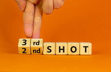 Covid-19 booster vaccine shot symbol. Doctor turns cubes and changes words '2nd shot' to '3rd shot'. Beautiful orange background, copy space. Covid-19 booster vaccine shot concept.