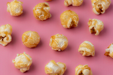 Toffee popcorn on a bright pink background in an abstract layout