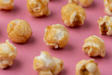 Toffee popcorn on a bright pink background in an abstract layout