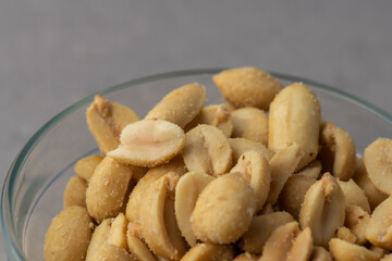 Salted peanuts closeup macro image in a glass bowl, background image copy space