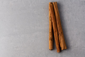 Cinnamon sticks top down on a grey slate texture background with copy space