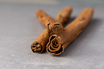 Cinnamon sticks led down on a grey slate texture background close up macro angle