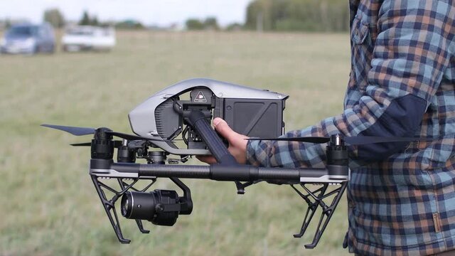 Man pilot checking quadcopter drone before aerial flight and filming