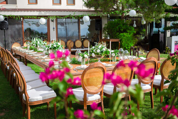 Fototapeta na wymiar Wedding preparation restaurant and wedding planners.Chairs and honeymooners table decorated with candles, served with cutlery and crockery and covered with a table cloth. wedding area, party area